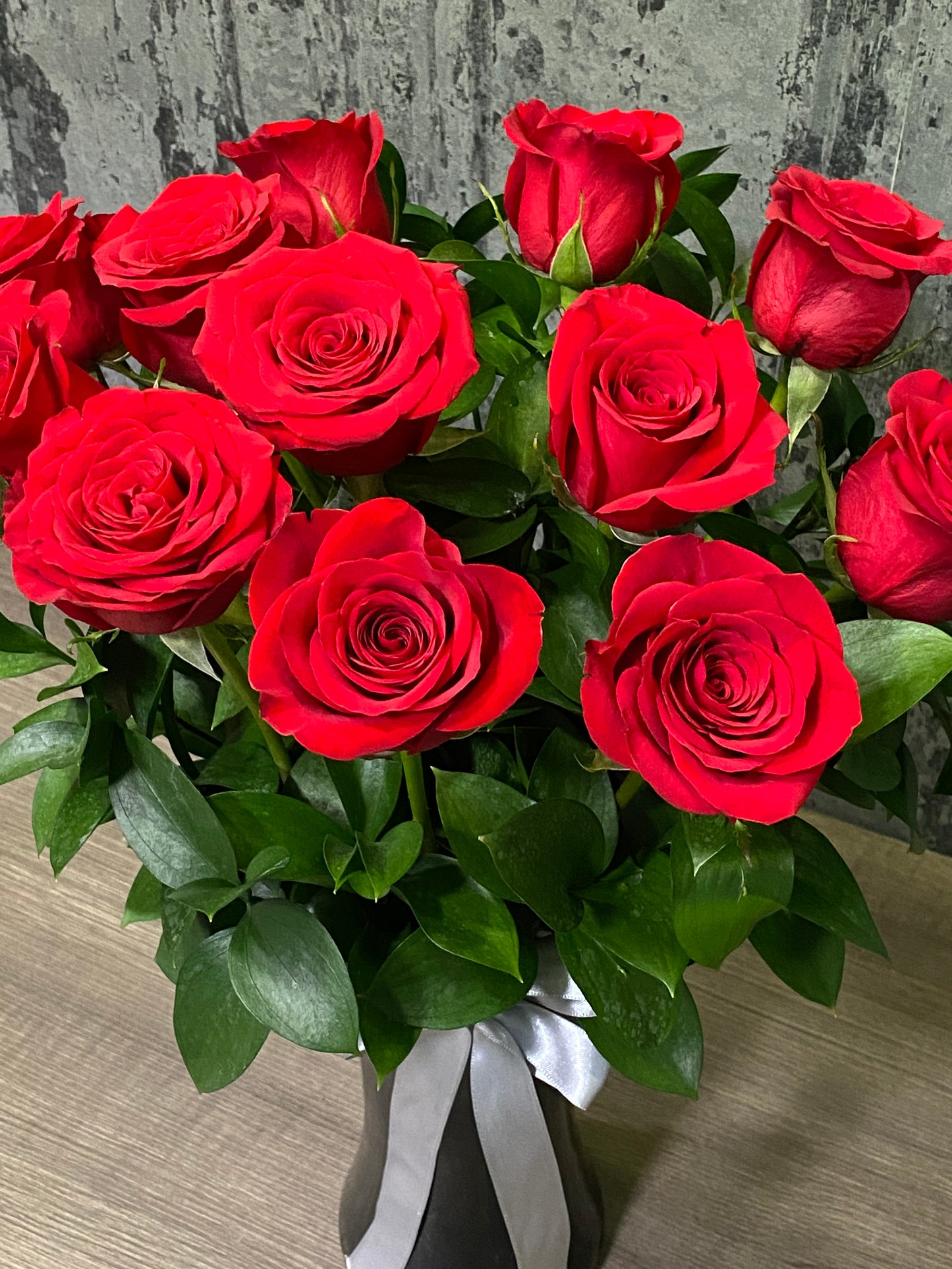 12 rosas rojas en florero